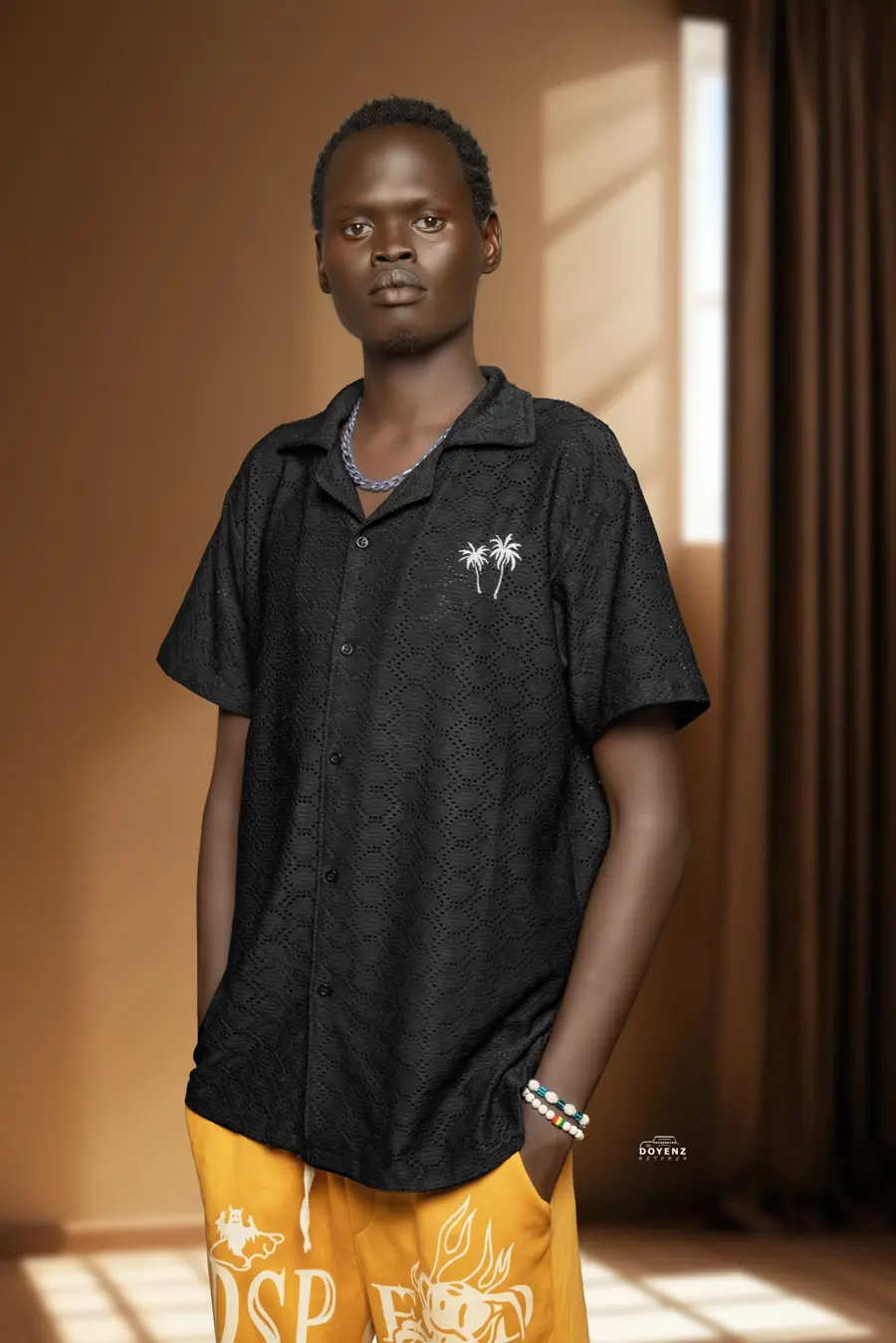 Xtion Jerry in a black shirt in a warm brown studio